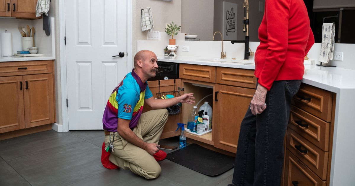 Image of a plumber inspecting a garbage disposal